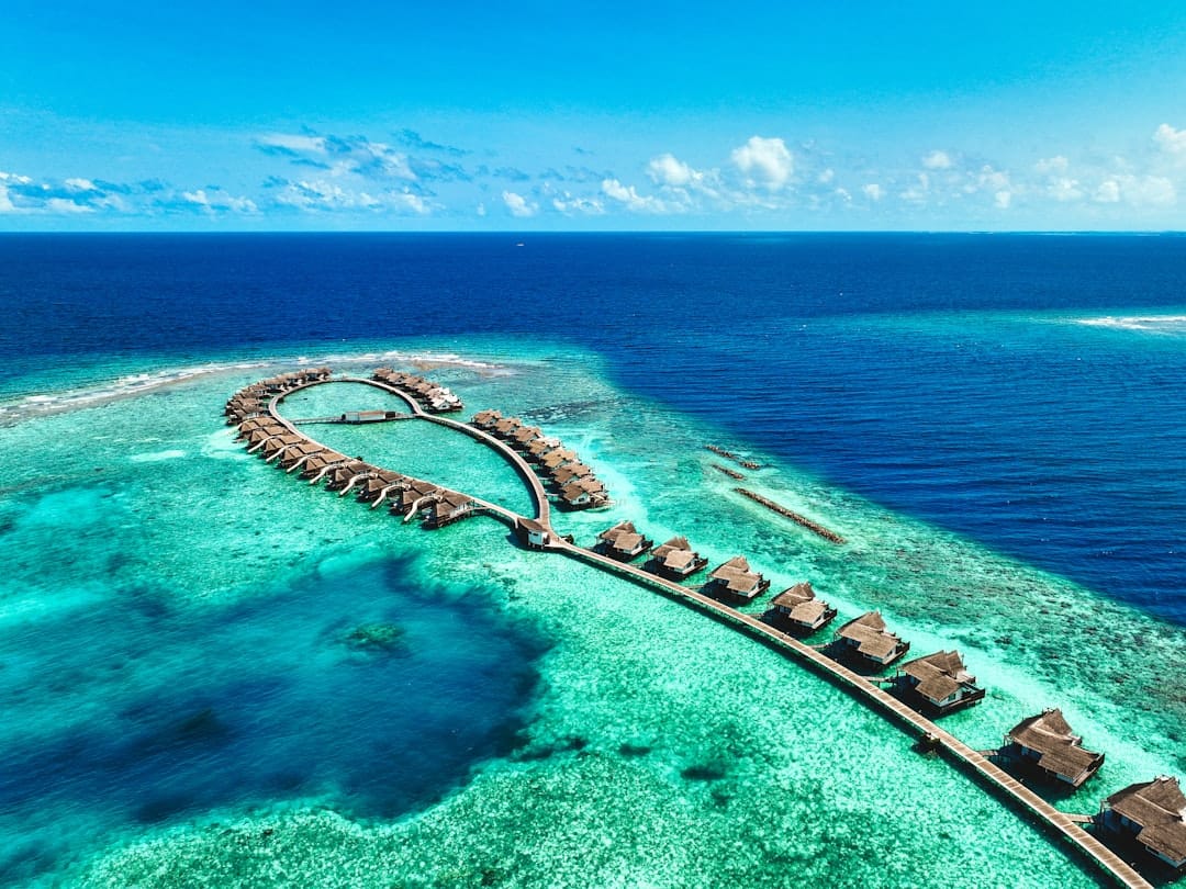 Overwater villas on stilts above a turquoise Maldives lagoon
