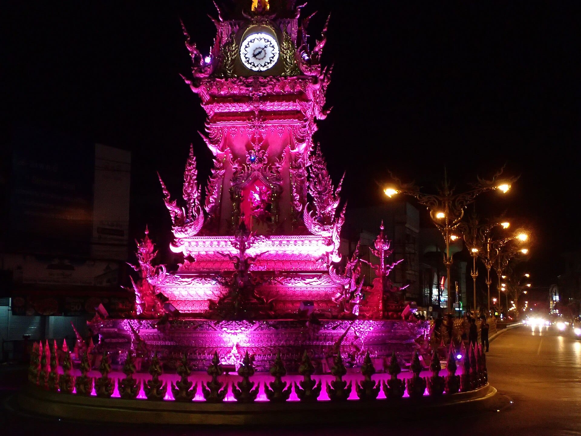 Chiang Rai's ornate golden clock tower lit magenta during its evening light show