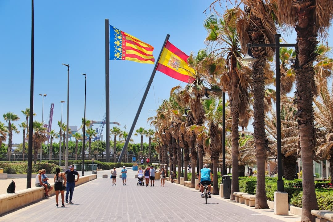 People walking along Valencia's seafront promenade beside the beach