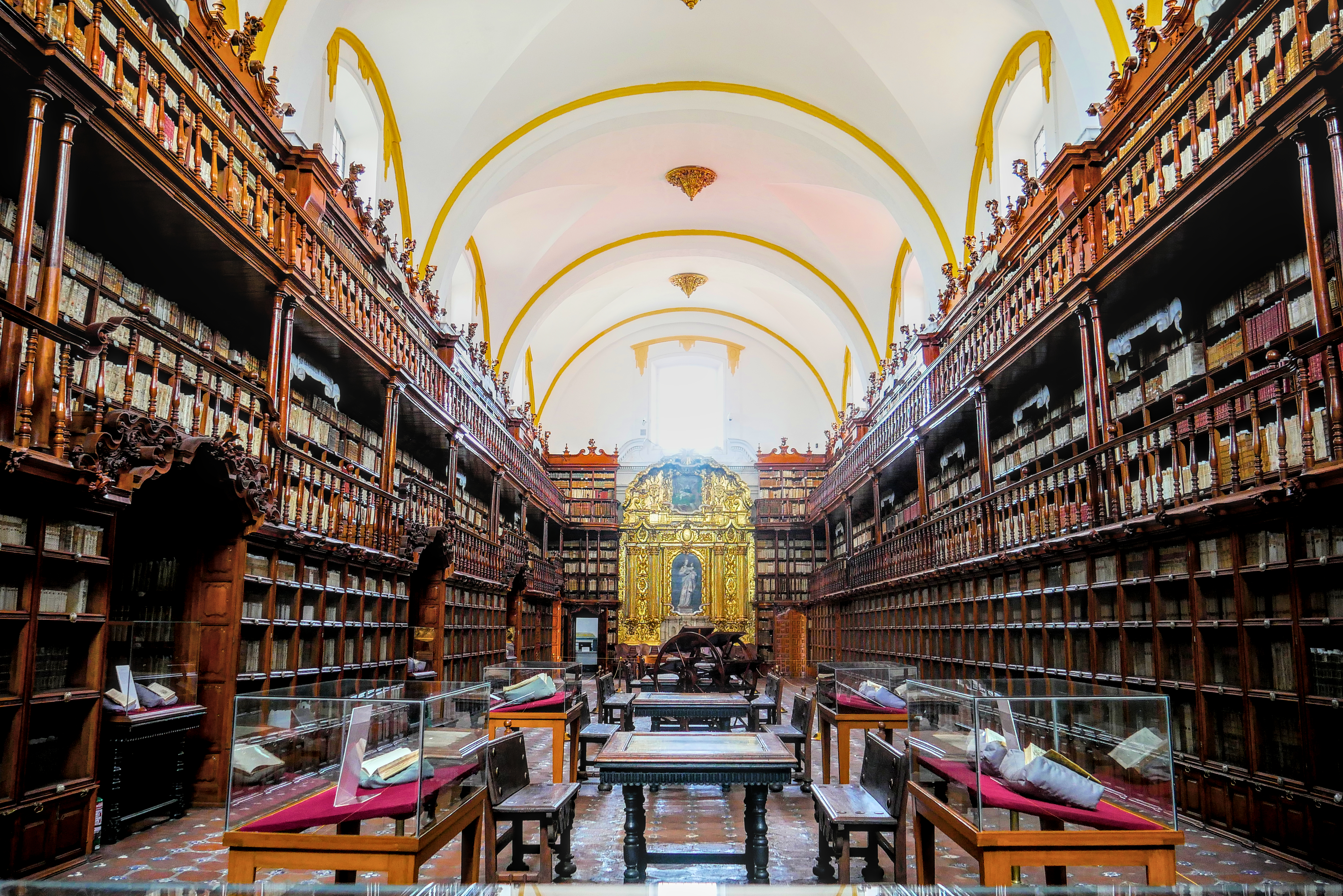 Interior of the Biblioteca Palafoxiana with three tiers of carved wooden shelves