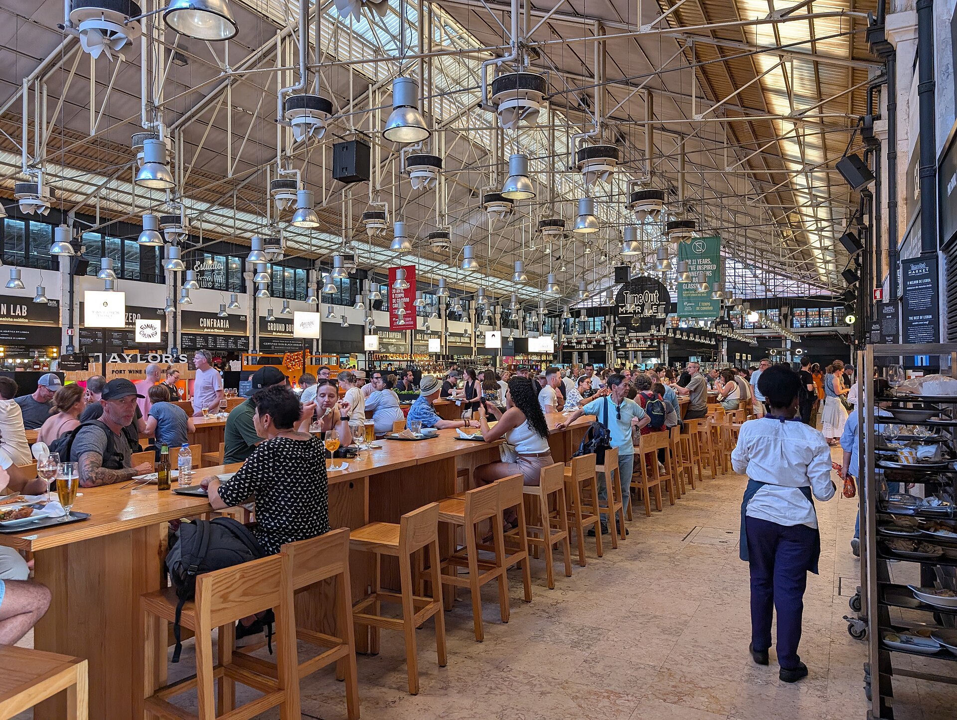 The busy interior of Time Out Market Lisbon with communal tables and food stalls
