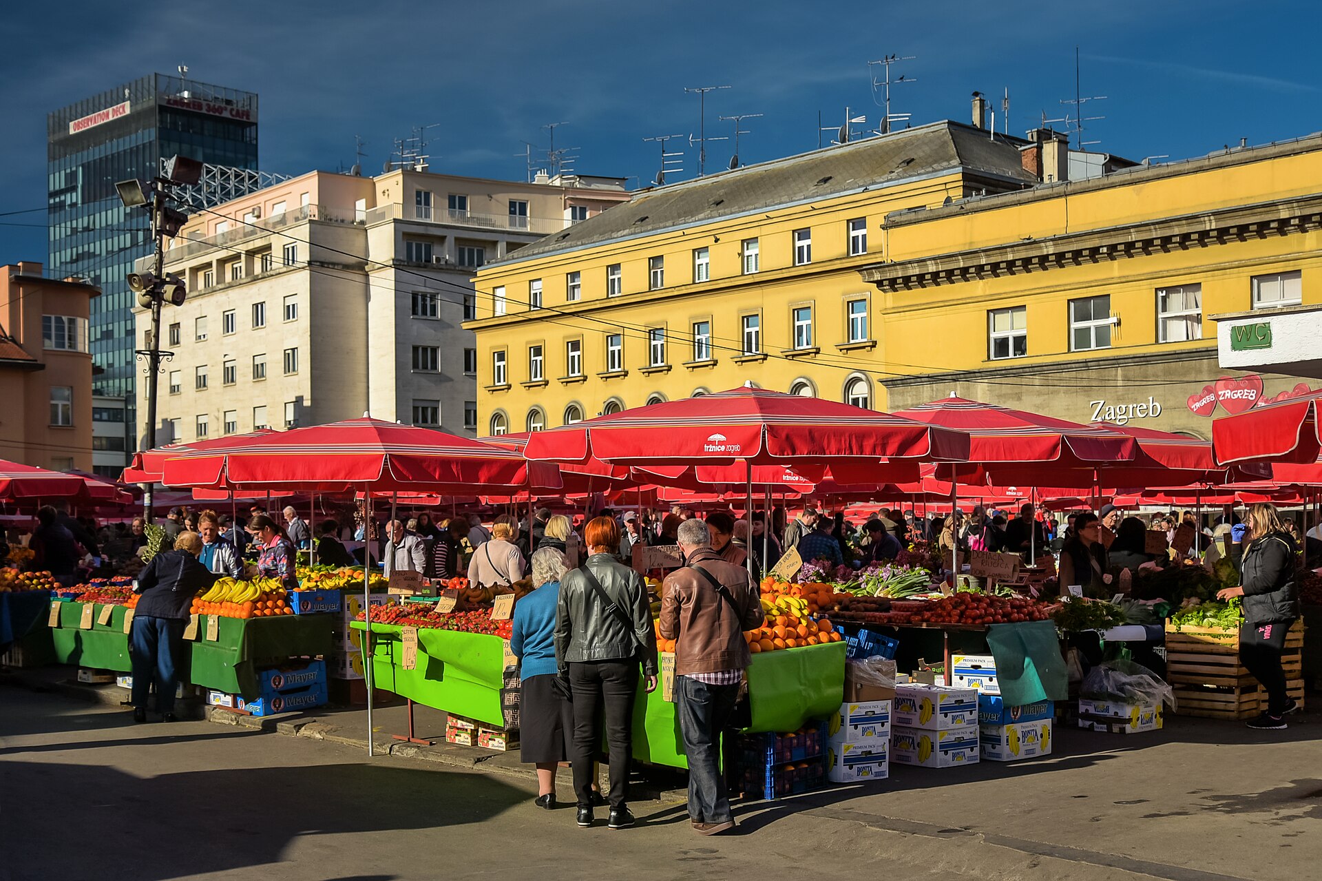 Dolac open-air market in Zagreb with rows of red parasols and fruit and vegetable stalls